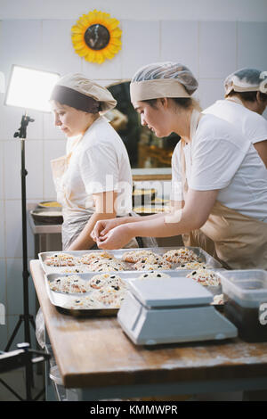 Mettre la garniture sur les cuisiniers la mini pizza Banque D'Images