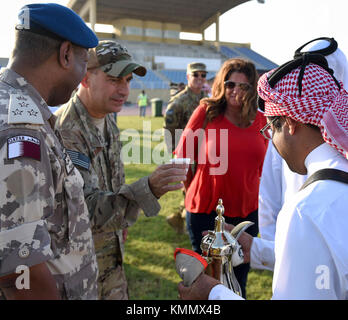 Les Qataris servent du café arabe au lieutenant général Jeffrey Harrigian, commandant de la composante aérienne des Forces combinées, à l'échange culturel de la Force aérienne du Qatar Emiri, le 1er décembre 2017. Plus de 620 militaires américains, partenaires de la Coalition, militaires qatari et membres de la famille ont profité d'une variété de cuisine et de boissons traditionnelles qatari, ainsi que d'une variété d'activités incluant des promenades à dos de chameau, de la fauconnerie et des manifestations culturelles. (É.-U. Force aérienne Banque D'Images