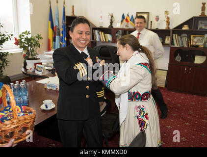 Roumanie (déc 1, 2017) Cmdr. Cathy Eyrich, à gauche, l'officier exécutif à bord de l'installation de soutien naval (NSF) Deveselu, est épinglé avec un drapeau roumain lors d'une célébration de la Grande Union. La grande fête de l'Union est une fête nationale roumaine qui a lieu chaque 1er décembre pour honorer l'Union de la Transylvanie et de la Roumanie. NSF Deveselu et Aegis ashore système de défense antimissiles la Roumanie sont coimplantés avec la 99e base militaire roumaine et jouent un rôle clé dans la défense antimissiles balistiques en Europe de l'est. (É.-U. Marine Banque D'Images