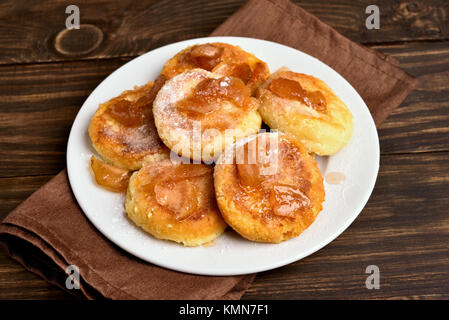 Beignets, crêpes au fromage blanc avec des tranches de pommes caramélisées sur la plaque. Vue rapprochée Banque D'Images