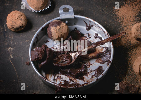 Plaque en aluminium avec le mélange de chocolat pour faire des truffes au chocolat et les truffes au chocolat maison sombre sur table. Banque D'Images