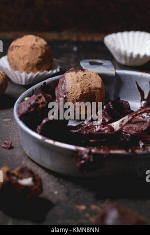 Plaque en aluminium avec le mélange de chocolat pour faire des truffes au chocolat et les truffes au chocolat maison sombre sur table. Banque D'Images