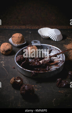 Plaque en aluminium avec le mélange de chocolat pour faire des truffes au chocolat et les truffes au chocolat maison sombre sur table. Banque D'Images