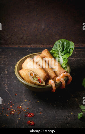 Rouleaux de printemps frits avec légumes et crevettes, servi dans Bol en céramique sur fond noir. Banque D'Images