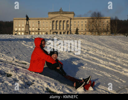 Natalie Trotter et son fils Logan, 9, essayez la luge au motif de Stormont Estate, Belfast, en tant que parties du Royaume-Uni et l'Irlande s'est réveillé d'une couche de neige causé par un flux d'air arctique dans le sillage de la tempête Caroline. Photo date : vendredi 8 décembre 2017. Histoire voir l'activité de Caroline météo. Crédit photo doit se lire : Brian Lawless/PA Wire Banque D'Images