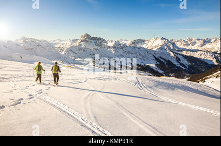 Deux randonneurs en raquettes au coucher du soleil dans les montagnes d'hiver des Alpes. La Bavière, Allemagne. Banque D'Images