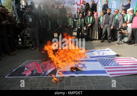 Gaza, bande de Gaza, territoire palestinien. 8 décembre 2017. Les Palestiniens brûlent des affiches représentant le président américain Donald Trump, le premier ministre israélien Benjamin Netanyahu, un drapeau israélien et un drapeau américain dans un rassemblement contre la décision du président américain Donald Trump de reconnaître Jérusalem comme la capitale d'Israël dans la ville de Gaza. Israël a déployé des centaines d'officiers de police supplémentaires à la suite d'appels palestiniens à manifester après les principales prières hebdomadaires des musulmans contre la reconnaissance par le président américain Donald Trump de Jérusalem comme capitale d'Israël. Crédit : Mohammed Asad/APA Images/ZUMA Wire/Alay Live News Banque D'Images