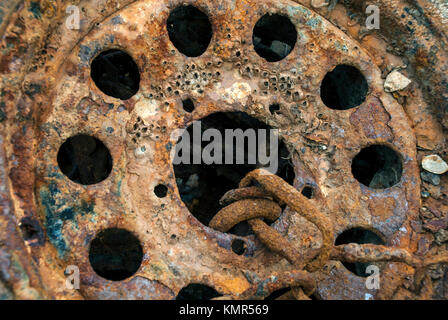 Close up image d'une roue couverte de balanes rouillée dans un ancien chantier naval Banque D'Images