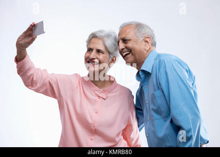 Happy senior couple using mobile phone selfies Banque D'Images
