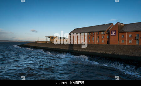 Premier Inn et David Lloyd Club, le port de Newhaven, Édimbourg, Écosse, Royaume-Uni, le clapotis des vagues avec brise-lames dans le Firth of Forth et ciel bleu Banque D'Images