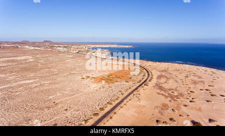 Vue aérienne de route passant par plage de sable blanc, de dunes vers station touristique de Corralejo , Fuerteventura, Îles Canaries, Espagne . Banque D'Images