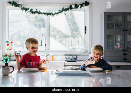 Heureux frères ayant dessert à table pendant noël à la maison Banque D'Images