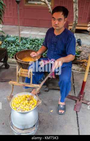 Bangkok, Thaïlande. Les cocons de soie brute d'ébullition, Jim Thompson House Démonstration. Banque D'Images