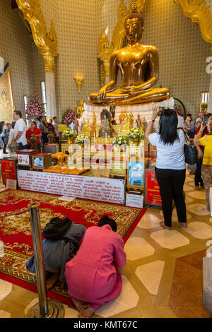 Bangkok, Thaïlande. Les fidèles se mêlent à des touristes à la Wat Traimit, le Temple du Bouddha d'or. Le bouddha est assis dans la geste Bhumisparsha, cal Banque D'Images