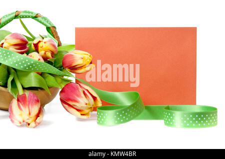 Panier de tulipes et une enveloppe orange Banque D'Images