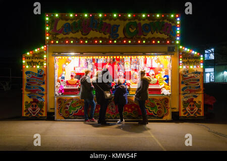 Une famille s'arrêter et jouer un jeu à rire clowns un stand à une foire. Banque D'Images