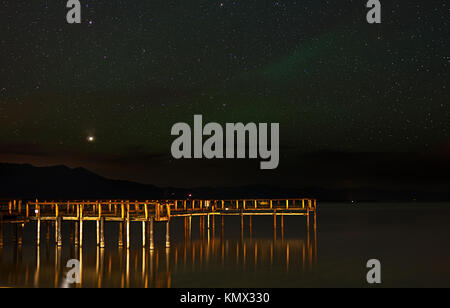 La Star Vegas sur le lac Tahoe avec Green Ionisation atmosphérique et d'étoiles dans le ciel, Golden Brown Pier reflétant dans l'eau Banque D'Images