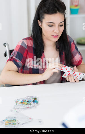 Mobilité young woman playing card game Banque D'Images