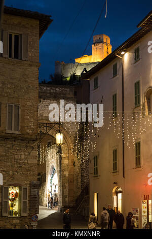 Vue d'une rue à Assise (Ombrie) pendant la période de Noël, avec des décorations et Rocca Maggiore en haut de la trame Banque D'Images