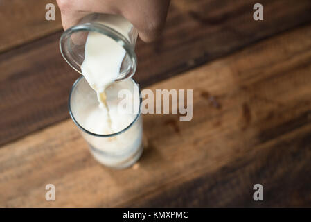 Close up - verser le lait en verre. Le remplissage d'un verre de lait. Banque D'Images