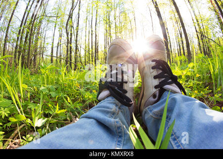 Femme jambes dans sneaker. jeter sur l'herbe verte Banque D'Images