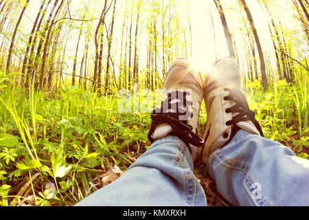 Femme jambes dans sneaker. jeter sur l'herbe verte Banque D'Images