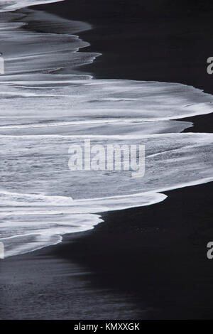 Vagues déferlaient sur la plage de sable noir à Kirkjufjara, le sud de l'Islande. Banque D'Images
