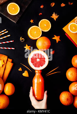 Jus d'oranges frais detox, pamplemousse et citron sur fond noir flay lay Banque D'Images