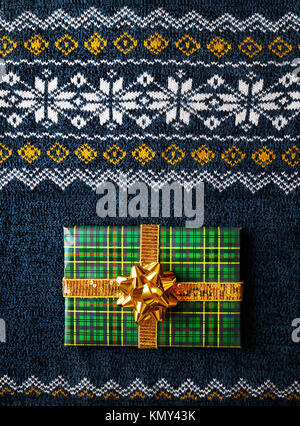 Green wrapped present avec archet d'or sur l'homme pour homme à l'époque de Noël Banque D'Images