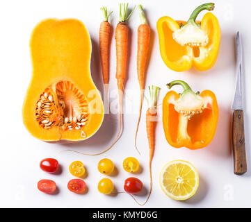 Jeu d'ensemble et les tranches de rouge, orange et jaune les légumes sur fond blanc. Vue d'en haut Banque D'Images