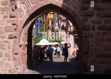 Les touristes de passage à travers la porte supérieure (Obertor) dans le 16ème siècle ville de Riquewihr sur la célèbre Route des vins en Alsace Banque D'Images