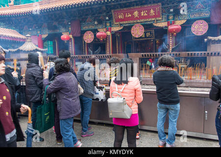 Les gens prient dans la cour du Temple Wong Tai Sin à Hong Kong Banque D'Images
