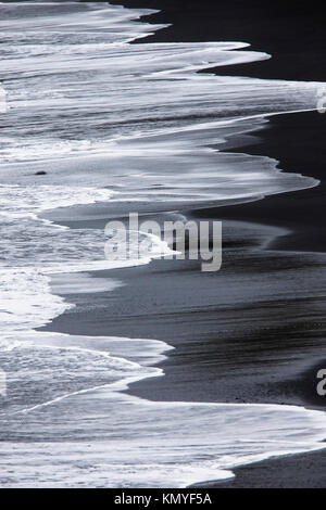 Vagues déferlaient sur la plage de sable noir à Kirkjufjara, le sud de l'Islande. Banque D'Images