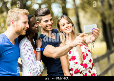 Groupe de jeunes et des couples en tenant vos autoportraits dans la nature Banque D'Images