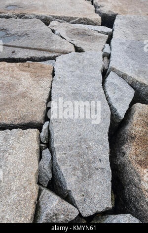Les rochers de granit qui composent une digue le long de la côte Atlantique Banque D'Images