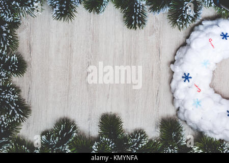 Noël ou Nouvel An bannière. Couronne de Noël blanc dans un cadre de branches d'arbre de Noël sur un fond de bois. Carte de vœux de Noël, vue d'en haut Banque D'Images