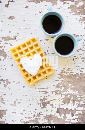 Gaufre belge et deux tasses de café sur une vieille table en bois Banque D'Images