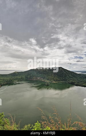 De fortes précipitations sur le point qui est un Vulcain petite île rocheuse à l'intérieur de cratère principal lac qui est sur une île dans un lac sur une île. Island-Taa volcan Banque D'Images