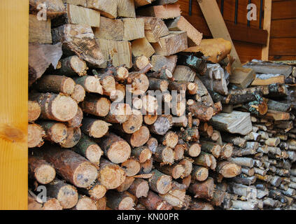 Bois scié et haché pour une cuisinière dans un bain. Un tas de bois près de la maison. Banque D'Images