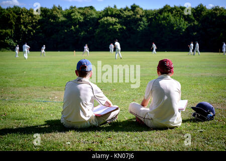 Deux jeunes garçons marquer un match de cricket Banque D'Images