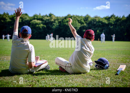 Deux jeunes garçons marquer un match de cricket Banque D'Images