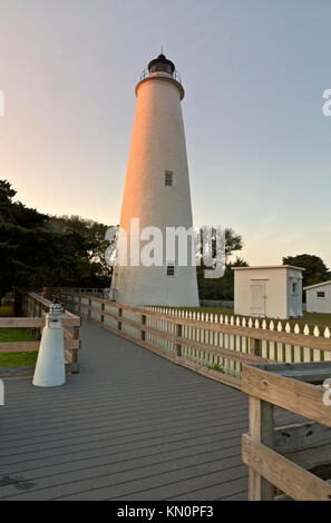 NC01034-00...CAROLINE DU NORD - promenade menant à la base d'Ocracoke Island phare au coucher du soleil sur les bancs extérieurs. Banque D'Images