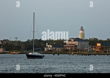 NC01037-00...CAROLINE DU NORD - Aube sur Silver Lake Harbour et l'Ocracoke Island phare sur les bancs extérieurs. Banque D'Images