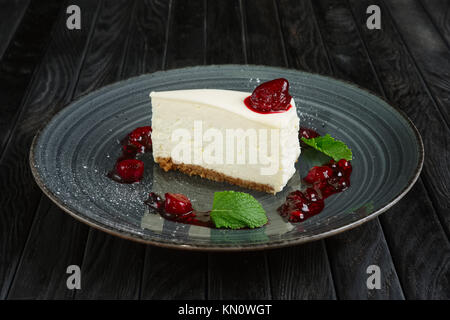 Morceau de fromage gâteau décoré avec cerise, fraise et framboise Banque D'Images