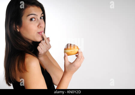 Young woman Eating donut sucré Banque D'Images