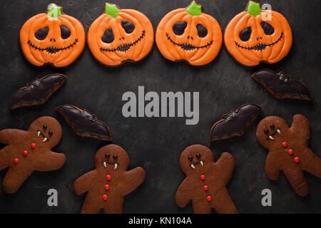 Les chauves-souris et de citrouille Halloween cookies passage tourné avec copie espace. Sur fond de béton foncé. Banque D'Images