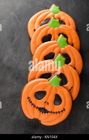 Gingerbread cookies faits maison pour l'halloween sous la forme de citrouilles sur fond de béton foncé. Vue d'en haut. Banque D'Images