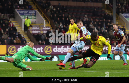 Watford gardien Heurelho Gomes (gauche) revendique la balle aux pieds de Burnley's Johann Berg Gudmundsson au cours de la Premier League match à Turf Moor, Burnley. Banque D'Images