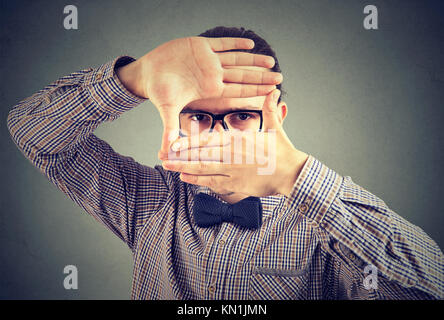 Homme sérieux faire un cadre avec ses mains looking at camera Banque D'Images