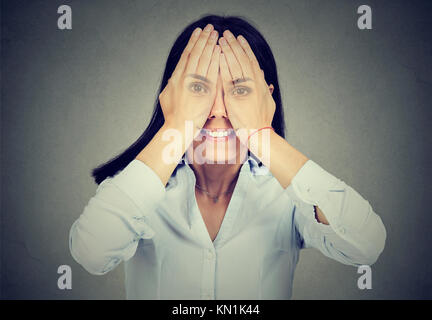 Portrait of a smiling woman covering her eyes Banque D'Images